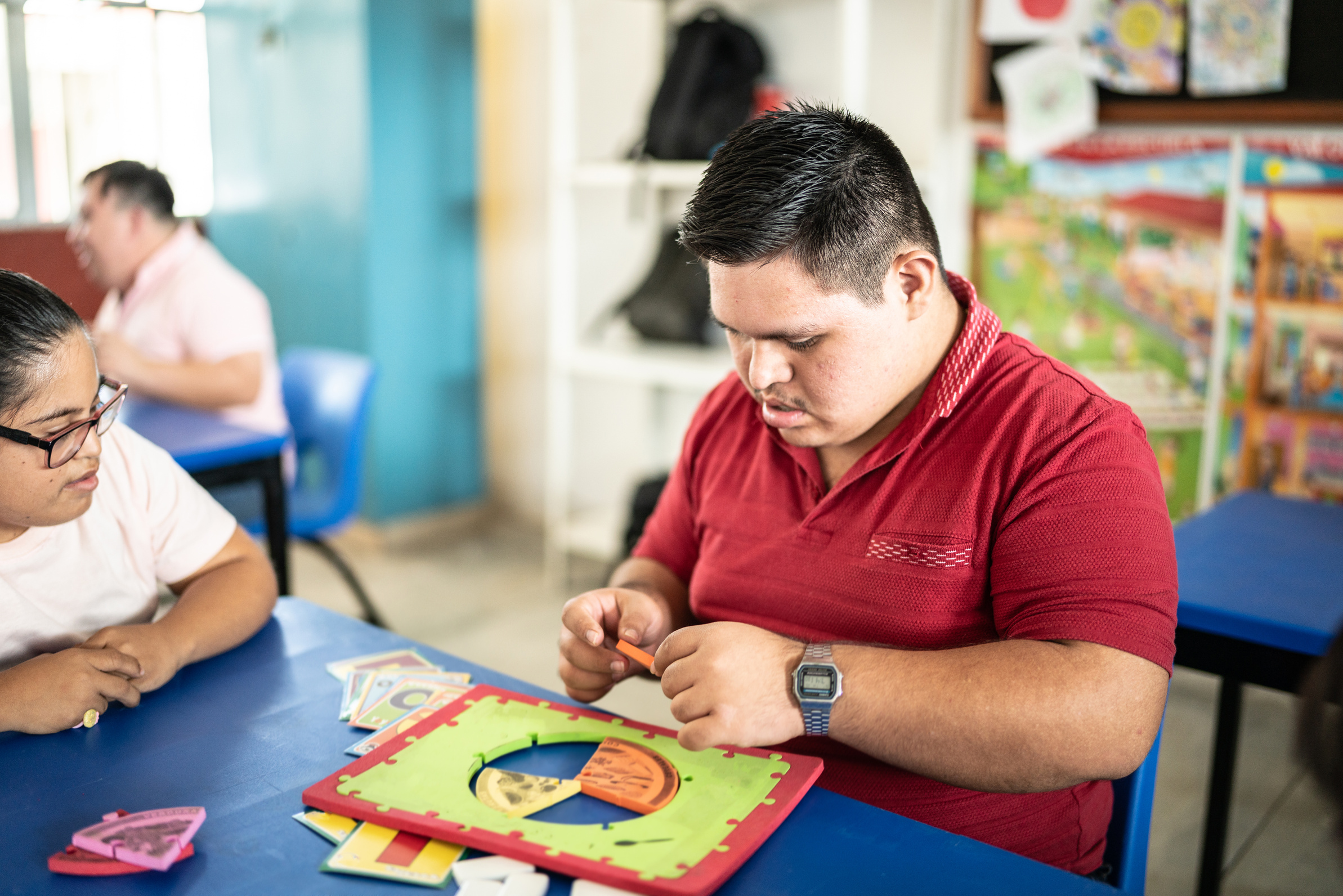 Special needs students playing with didactic toys in the classroom at school