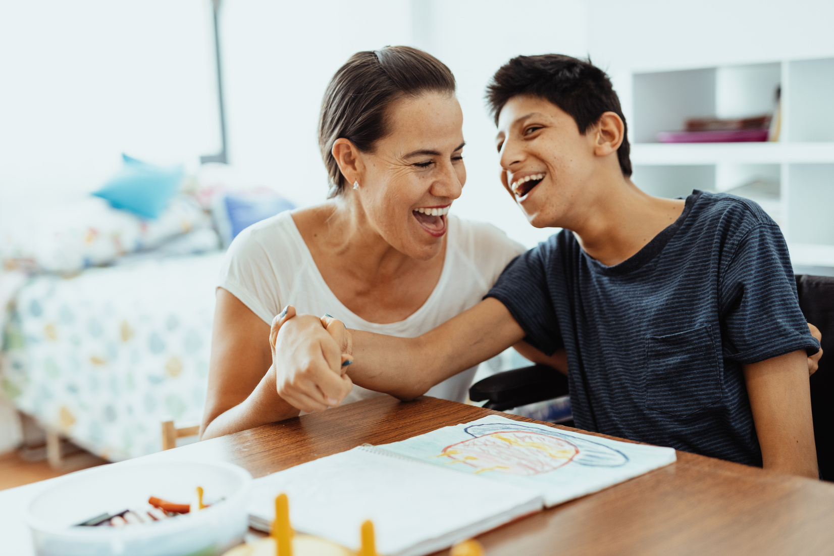 Children with disabilities learning better with parents. Woman and boy learning together